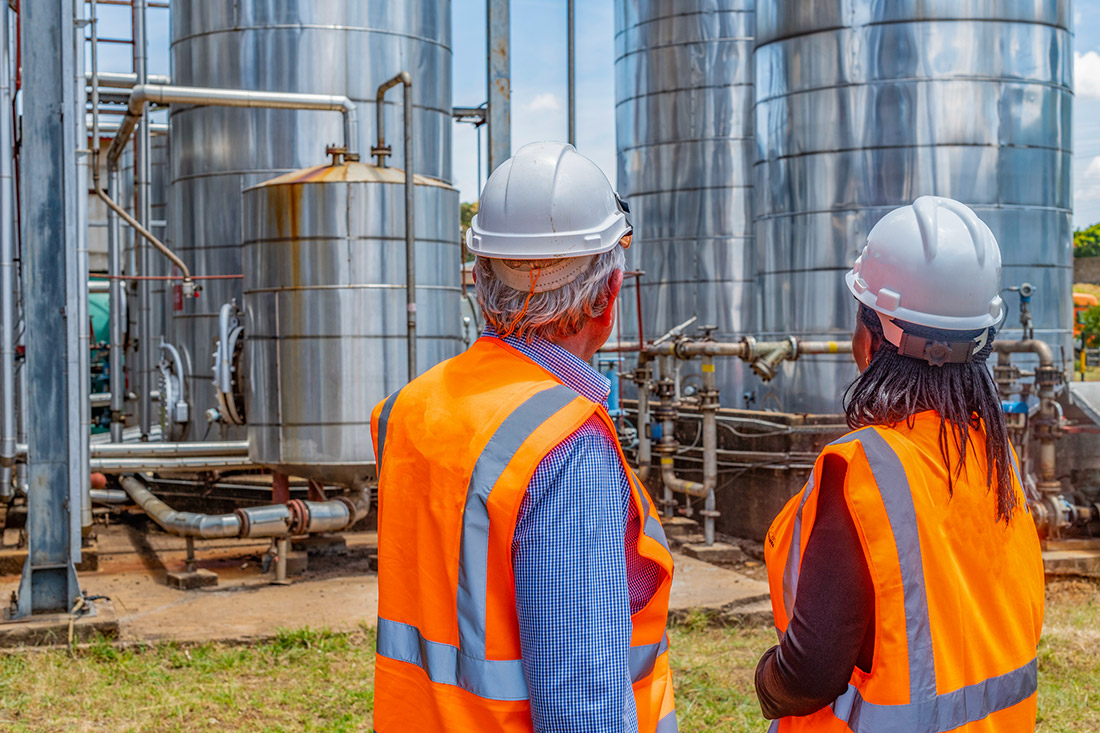 Two people standing in front of a carbon injection well